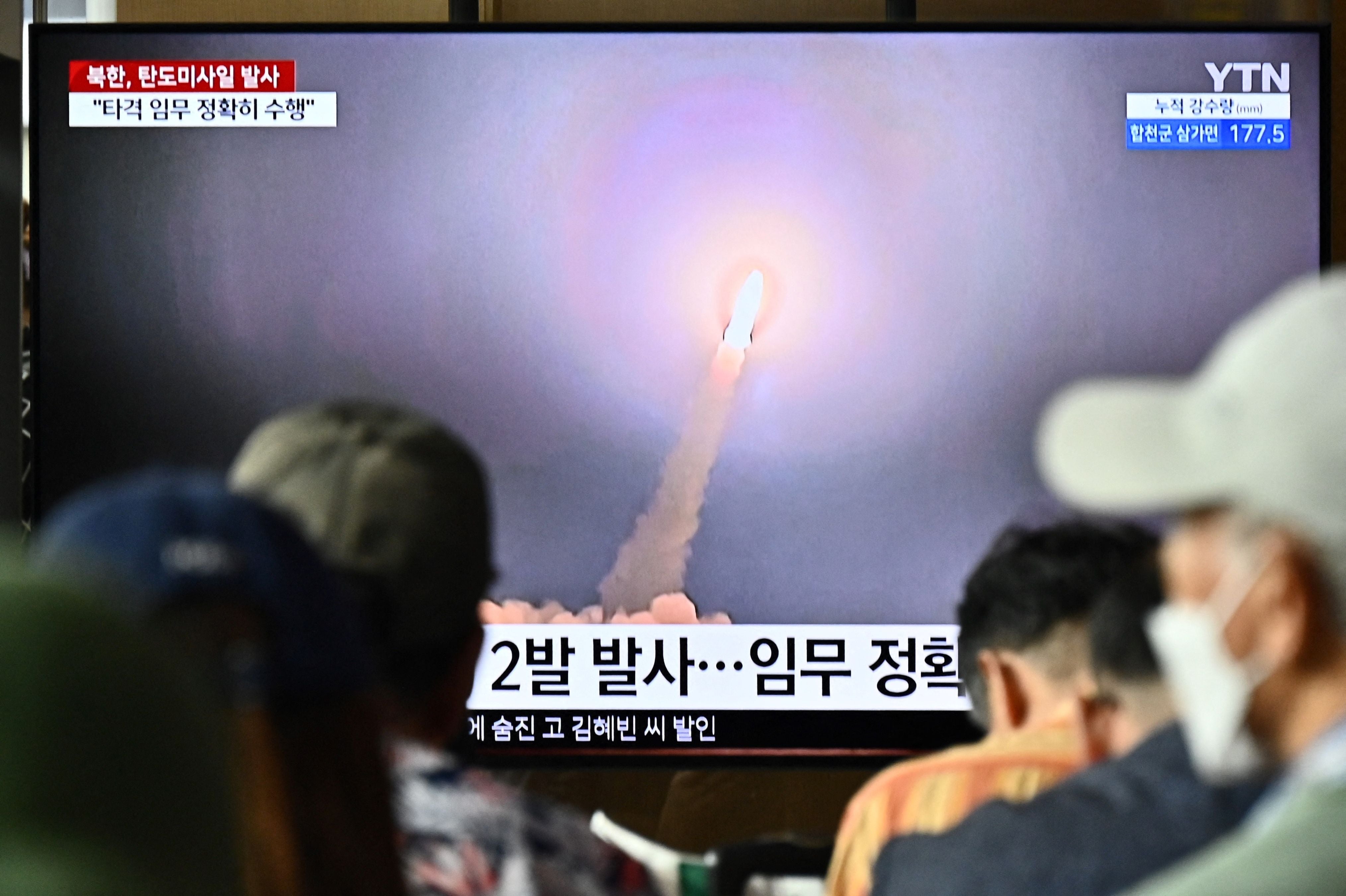 People watch a television showing a news broadcast with a photo of a North Korean missile test on 31 August