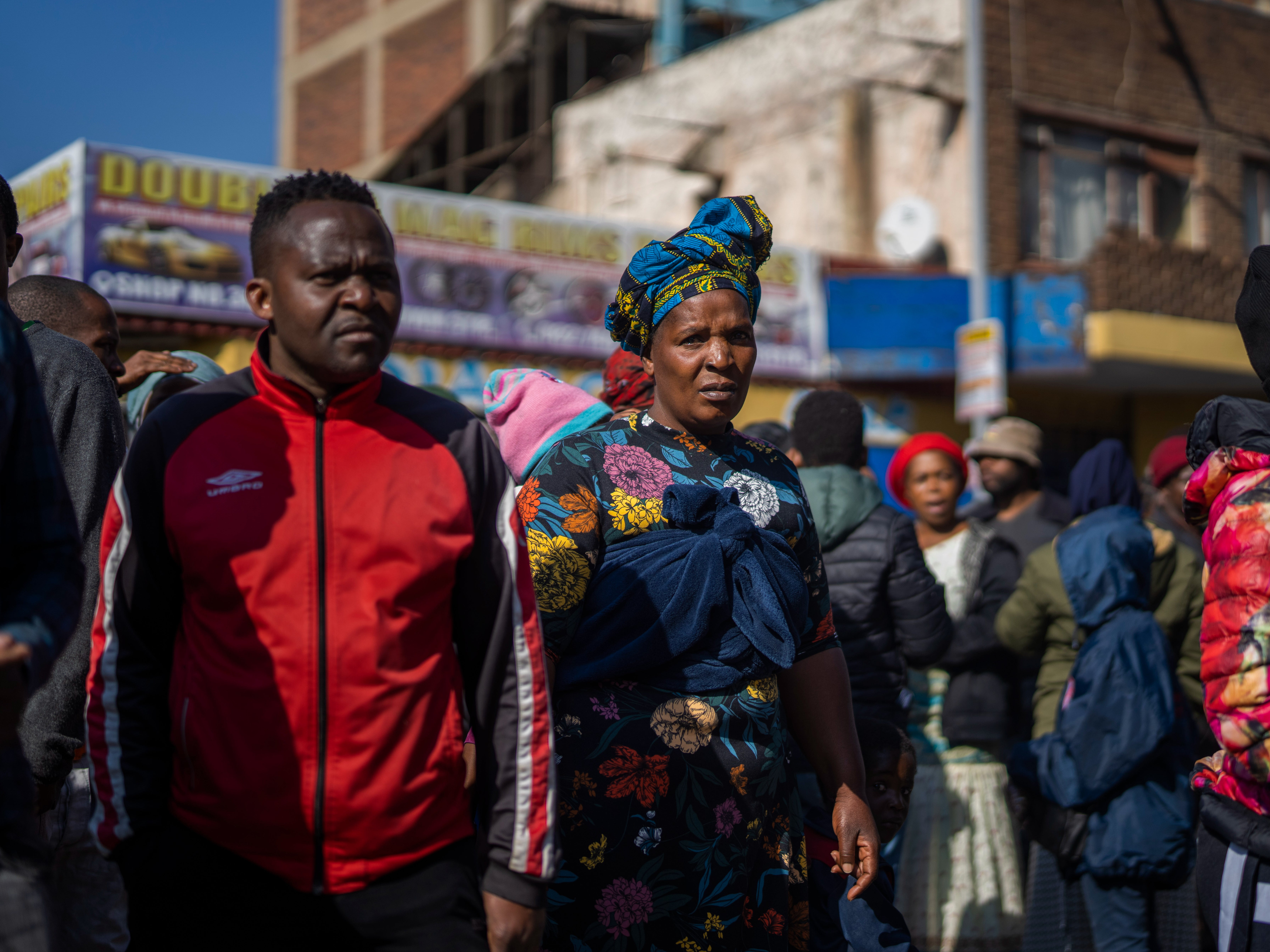 <p>People gather to watch rescue efforts at a multi-story building used by homeless people that caught fire, in downtown Johannesburg, South Africa, </p>