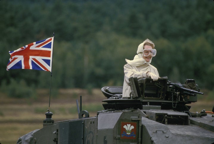 Margaret Thatcher showing off her googles while riding a British tank in West Germany