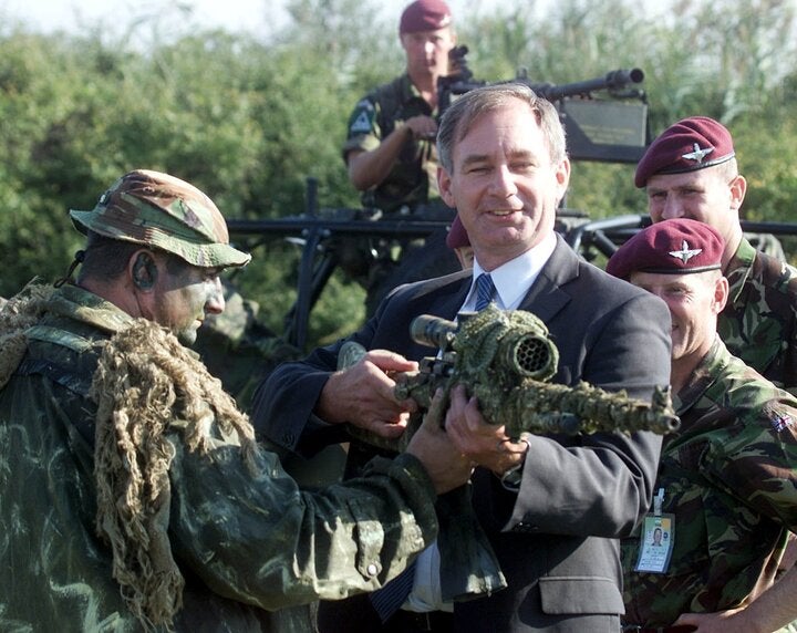 Geoff Hoon holding a sniping rifle in Macedonia