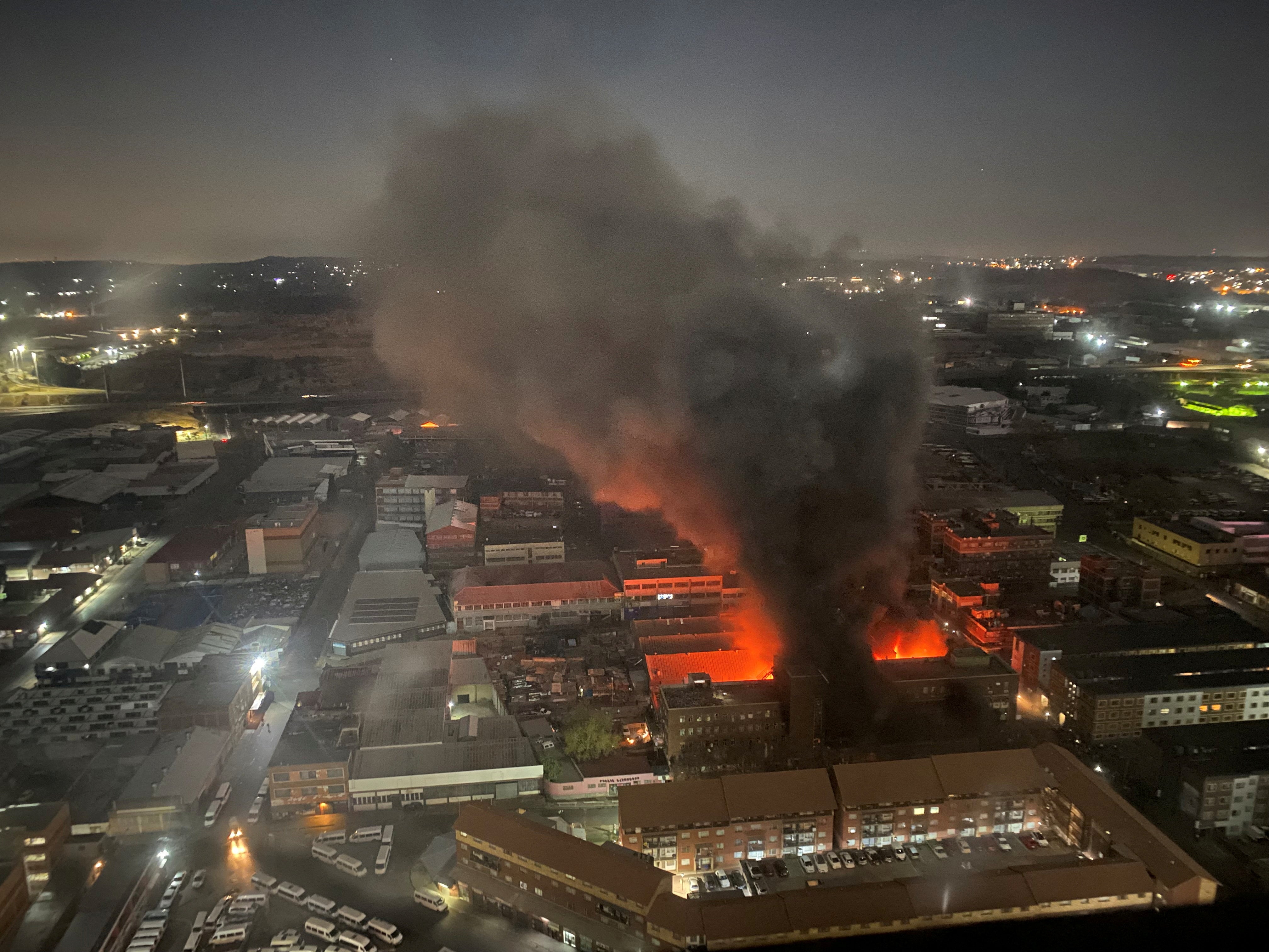 Smoke rises from the building amid the deadly fire