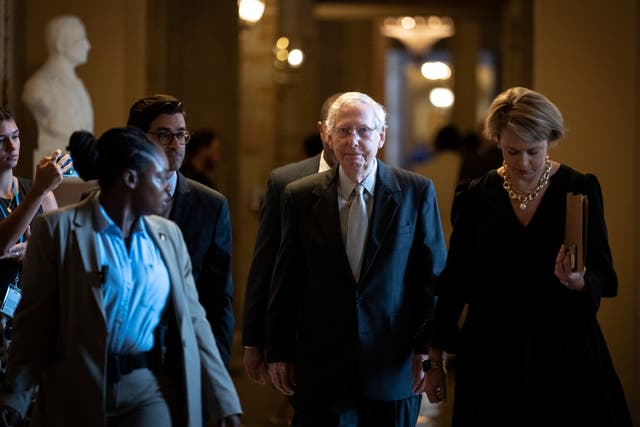 <p>Mitch McConnell walks with aides and reporters on Capitol Hill </p>