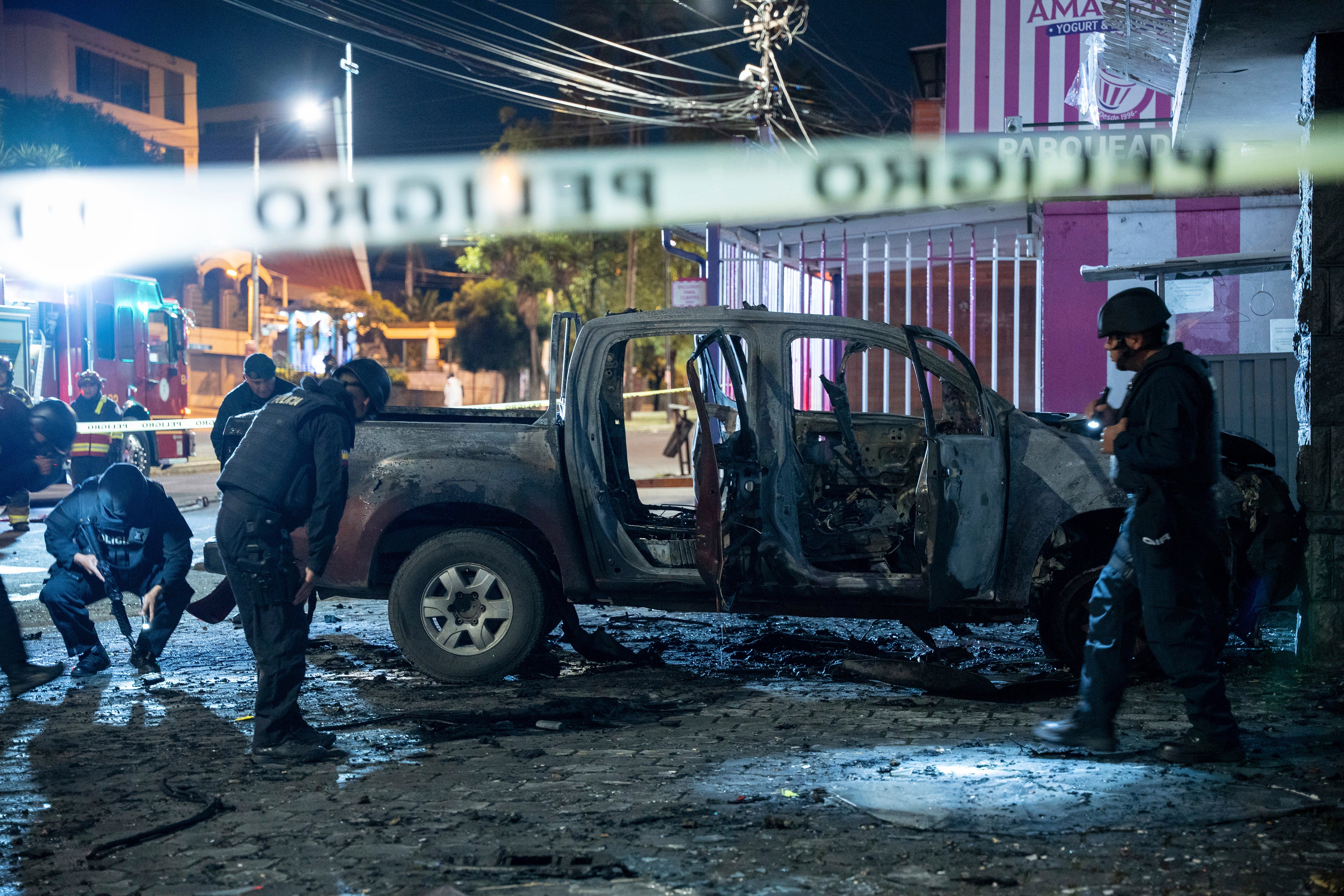 Police inspect a truck that exploded outside an office used by the government's National Service for Attention for People Deprived of Liberty (SNAI), which runs the jail system, in Quito