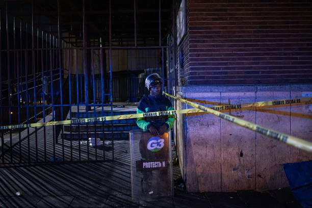 <p>A private security guard stands at the scene of a fire in Johannesburg on 31 August 2023</p>