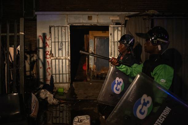 <p>Private security guards patrol the scene of a fire in Johannesburg on 31 August 2023</p>