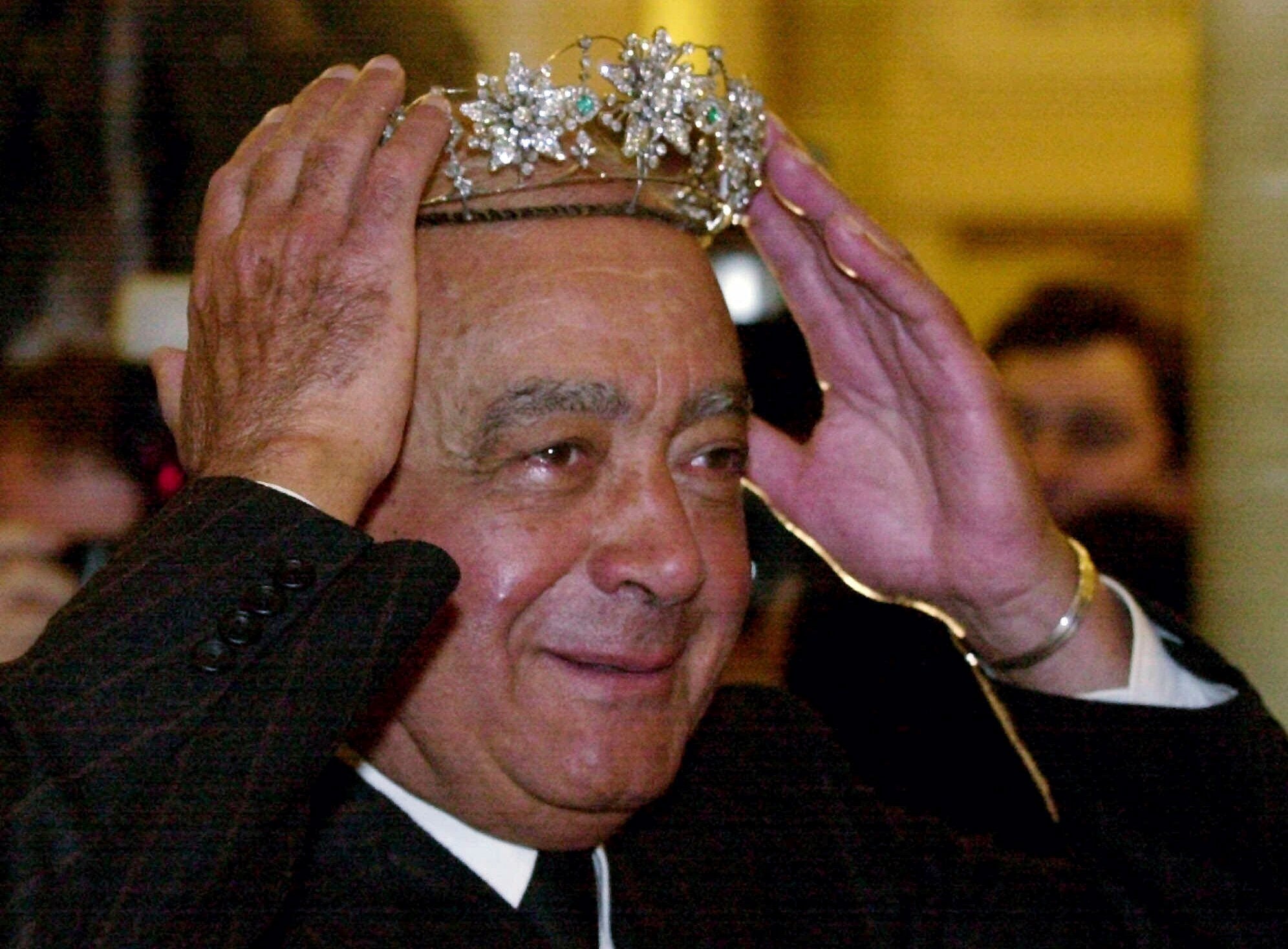 Mohamed Al-Fayed owner of Harrods department store, in London, tries on a tiara at the start of the January sales in January 2001