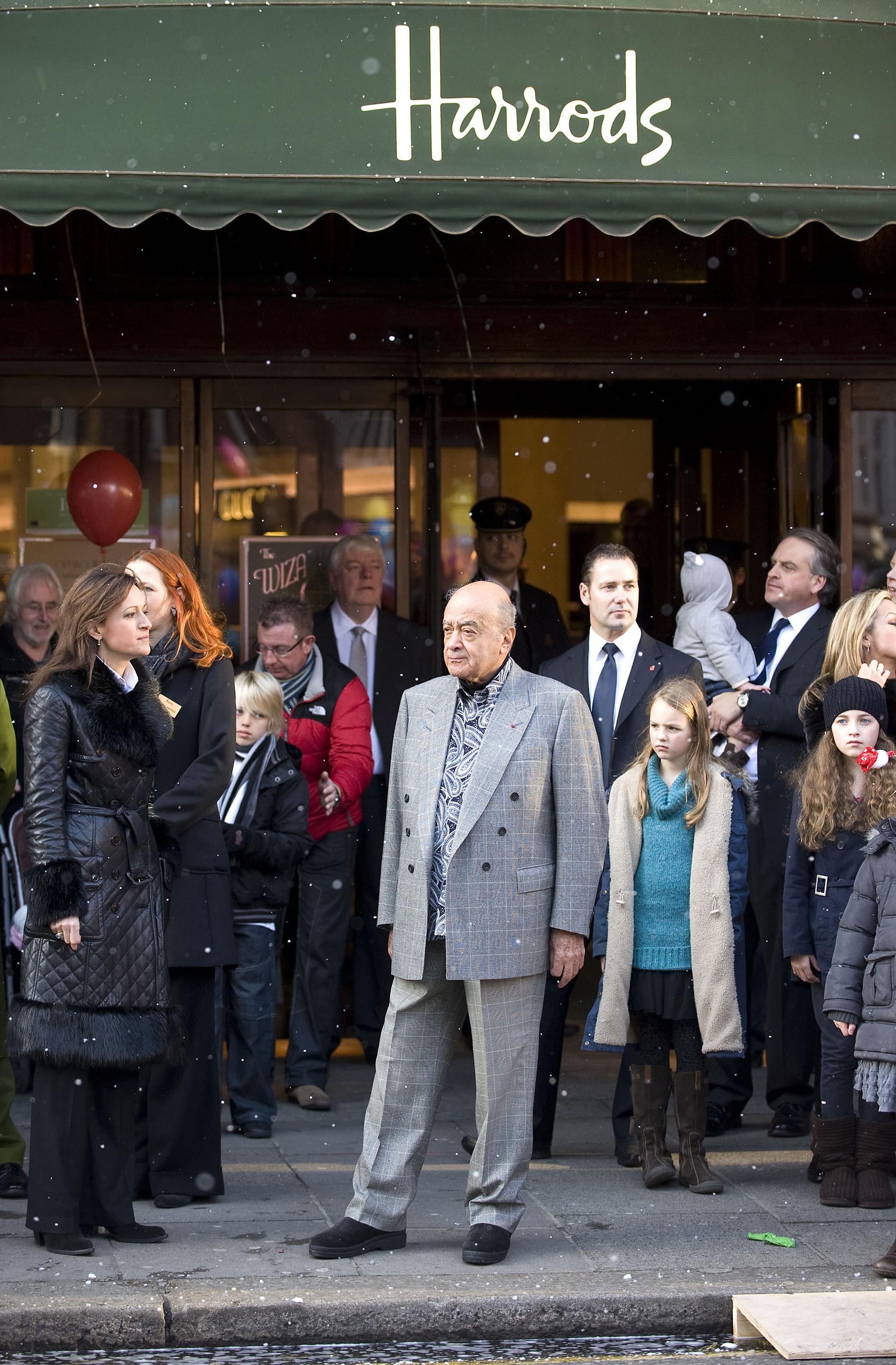 Mohammed Al Fayed stands outside his store as he watches the Harrods Christmas Parade on Brompton Road