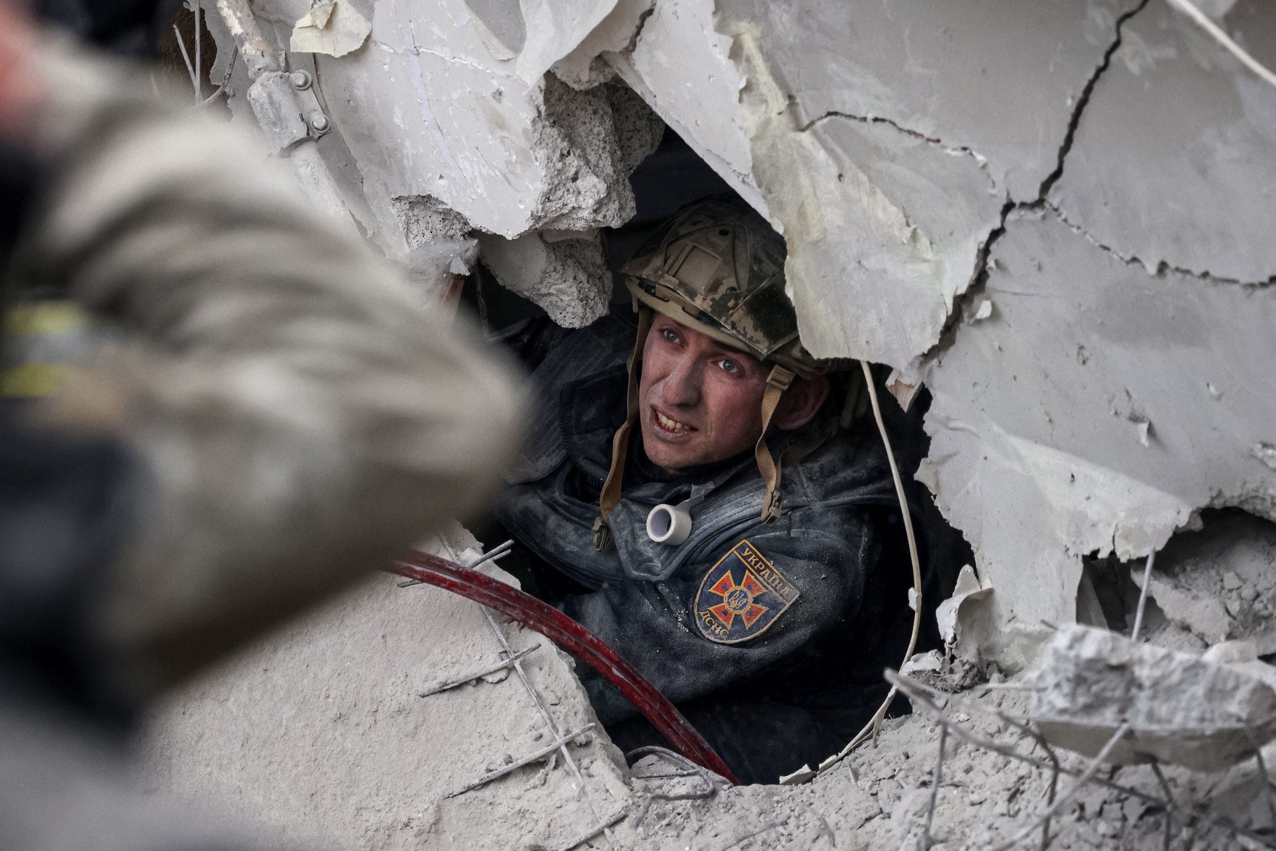A rescuer searches for survivors in a partially destroyed residential building after Russian shelling in Slovyansk