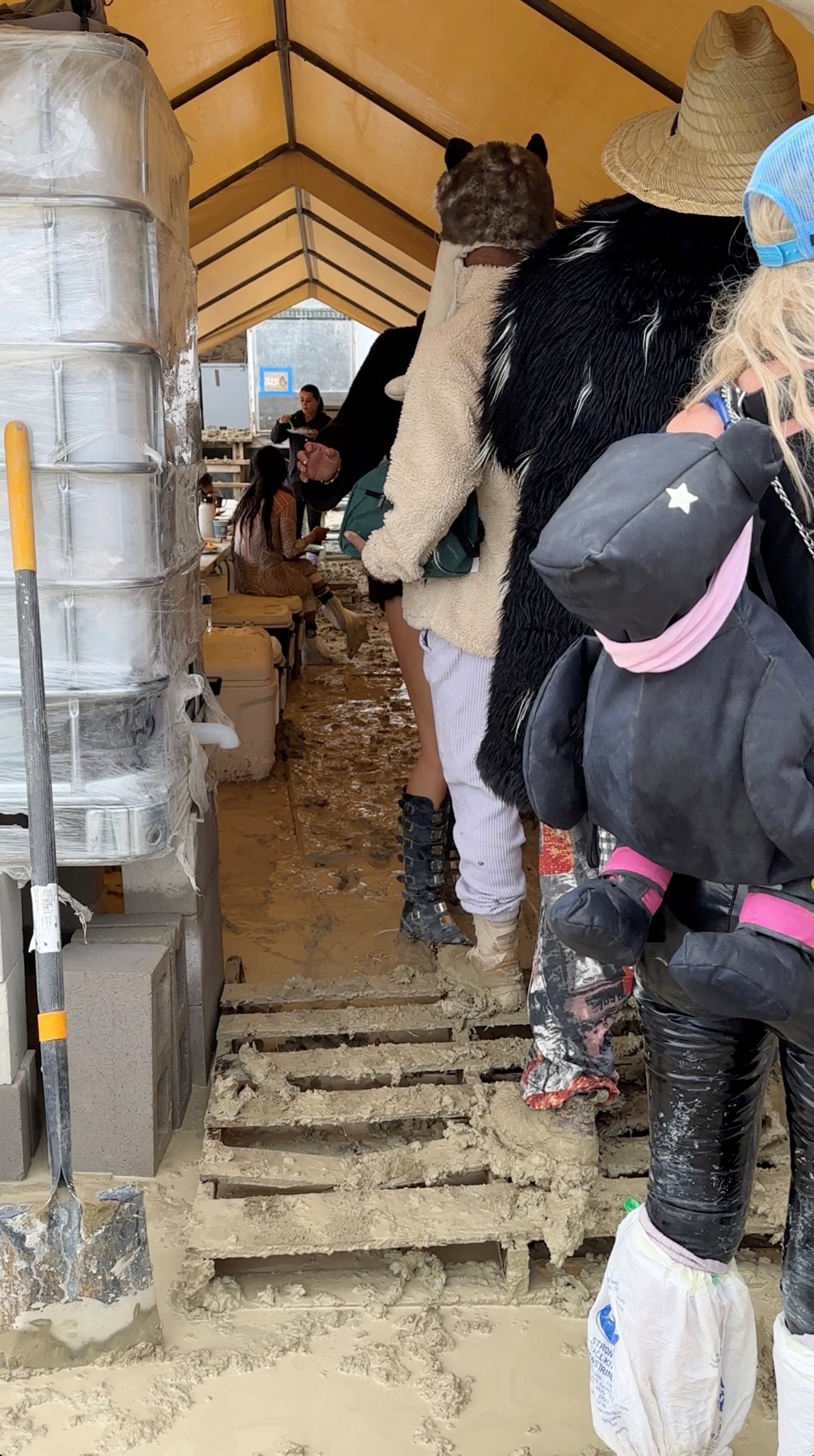 People use plastic bags to cover their shoes as others are seen with their boots covered in mud at the site of the Burning Man festival