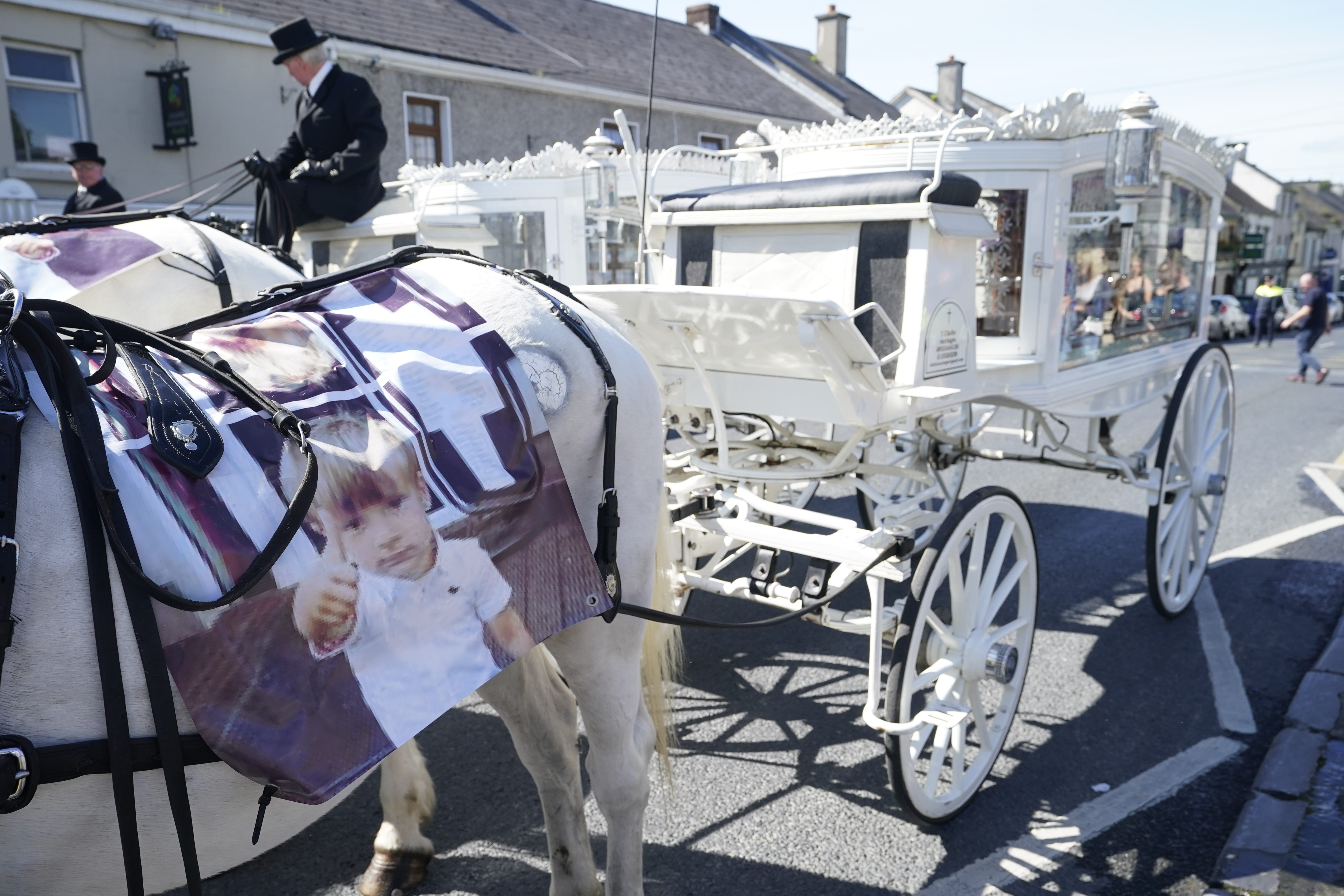 Horse-drawn carriages carrying the coffins of Thomas Reilly, 45, his wife Bridget Reilly, 46, and their three-year-old grandson Tom Reilly, arrive at St John the Baptist Church in Cashel, Co Tipperary, for their funeral service (Niall Carson/PA)
