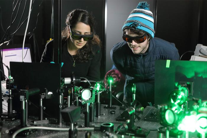 <p>Doctoral candidates Sara Makarem Hoseini and Daniel Hirt observe the plasma ray setup</p>