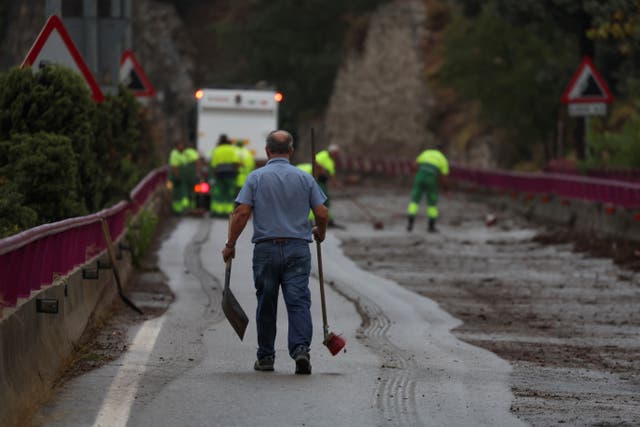 <p>Workers remove debris from a bridge, following flooding and heavy rain in Toledo, Spain </p>