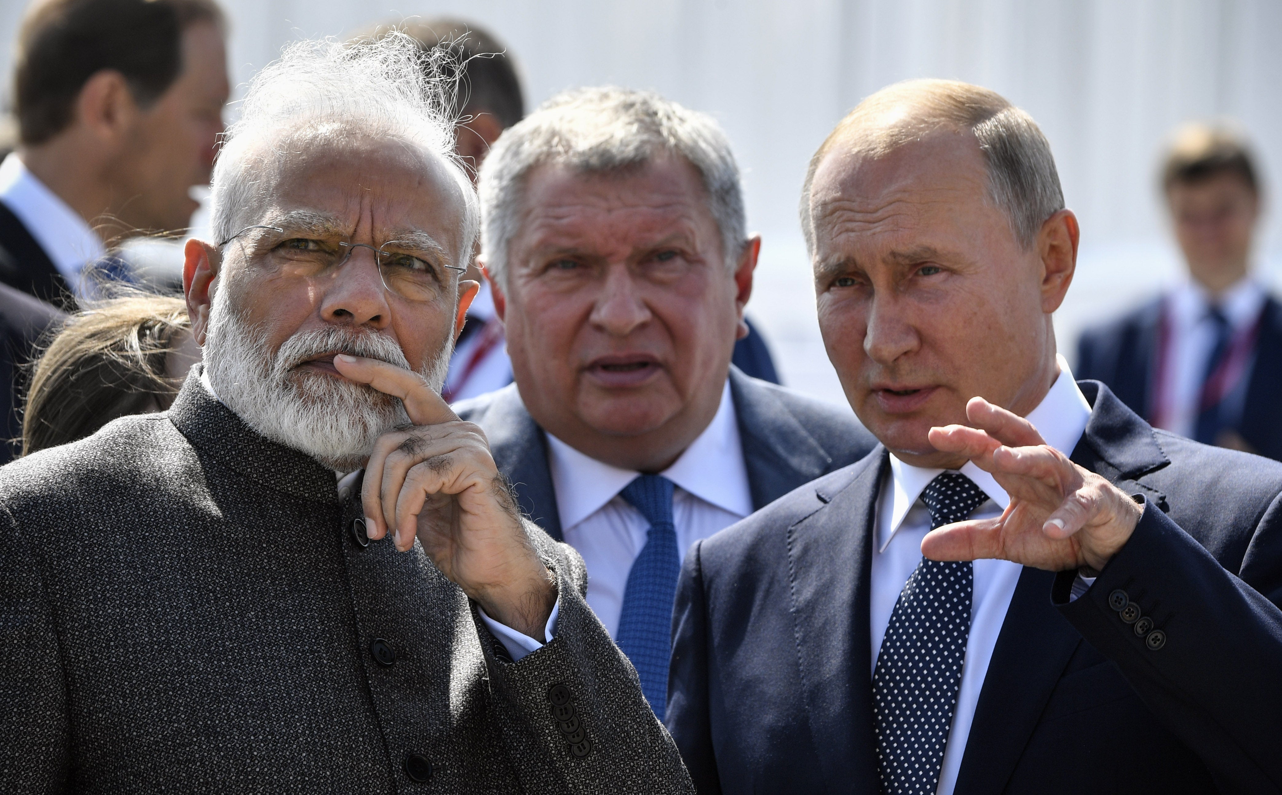 Russia’s president Vladimir Putin (R) speaks with India’s prime minister Narendra Modi (L) during a visit to the shipyard Zvezda, as Rosneft Russian oil giant chief Igor Sechin (C) accompanies them, outside the far-eastern Russian port of Vladivostok in 2019