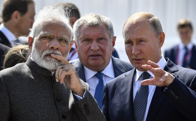 <p>Russia’s president Vladimir Putin (R) speaks with India’s prime minister Narendra Modi (L) during a visit to the shipyard Zvezda, as Rosneft Russian oil giant chief Igor Sechin (C) accompanies them, outside the far-eastern Russian port of Vladivostok in 2019 </p>