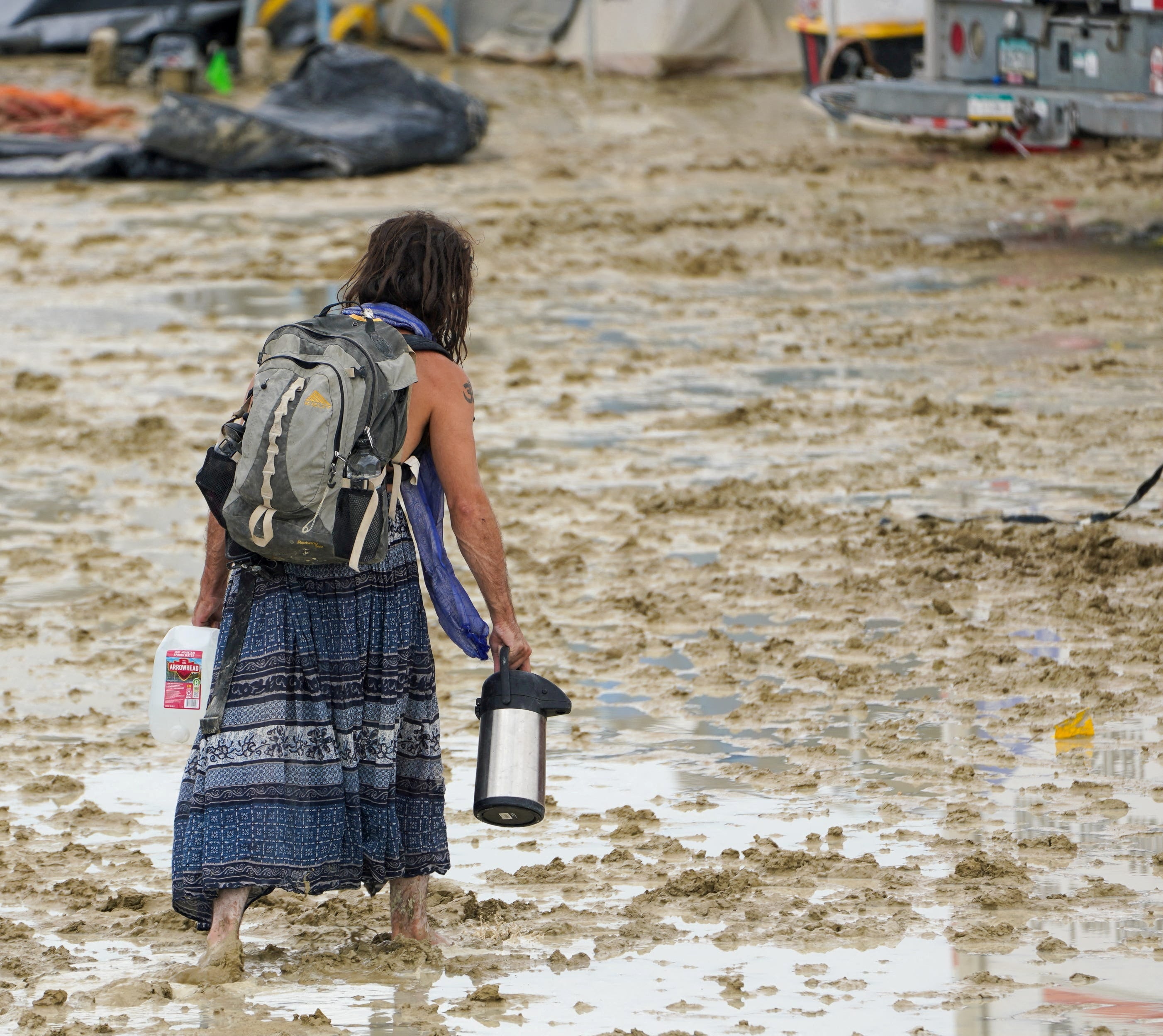 Reveller trudges through the mud at Burning Man