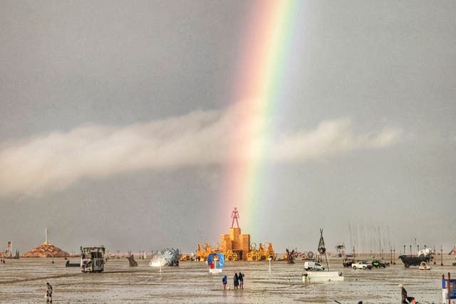 <p>This handout image provided courtesy of Josh Lease on September 3, 2023 shows a rainbow over flooding on a desert plain on September 1, 2023, after heavy rains turned the annual Burning Man festival </p>