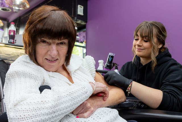 Alexa Peach, 56, from Sutton Coldfield, getting her first tattoo of a peach design to pay homage to her surname (Shaun Fellows/PA)