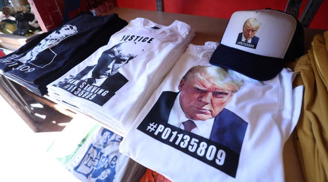 <p>T-shirts and hats with an image depicting the mugshot of former US president Donald Trump are pictured after being printed at the Y-Que printing store in Los Angeles, California, US, 26 August 2023</p>