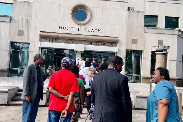 <p>A line of people forms outside federal court in Alabama on 14 August for a hearing on congressional districts previously rejected by the courts. </p>