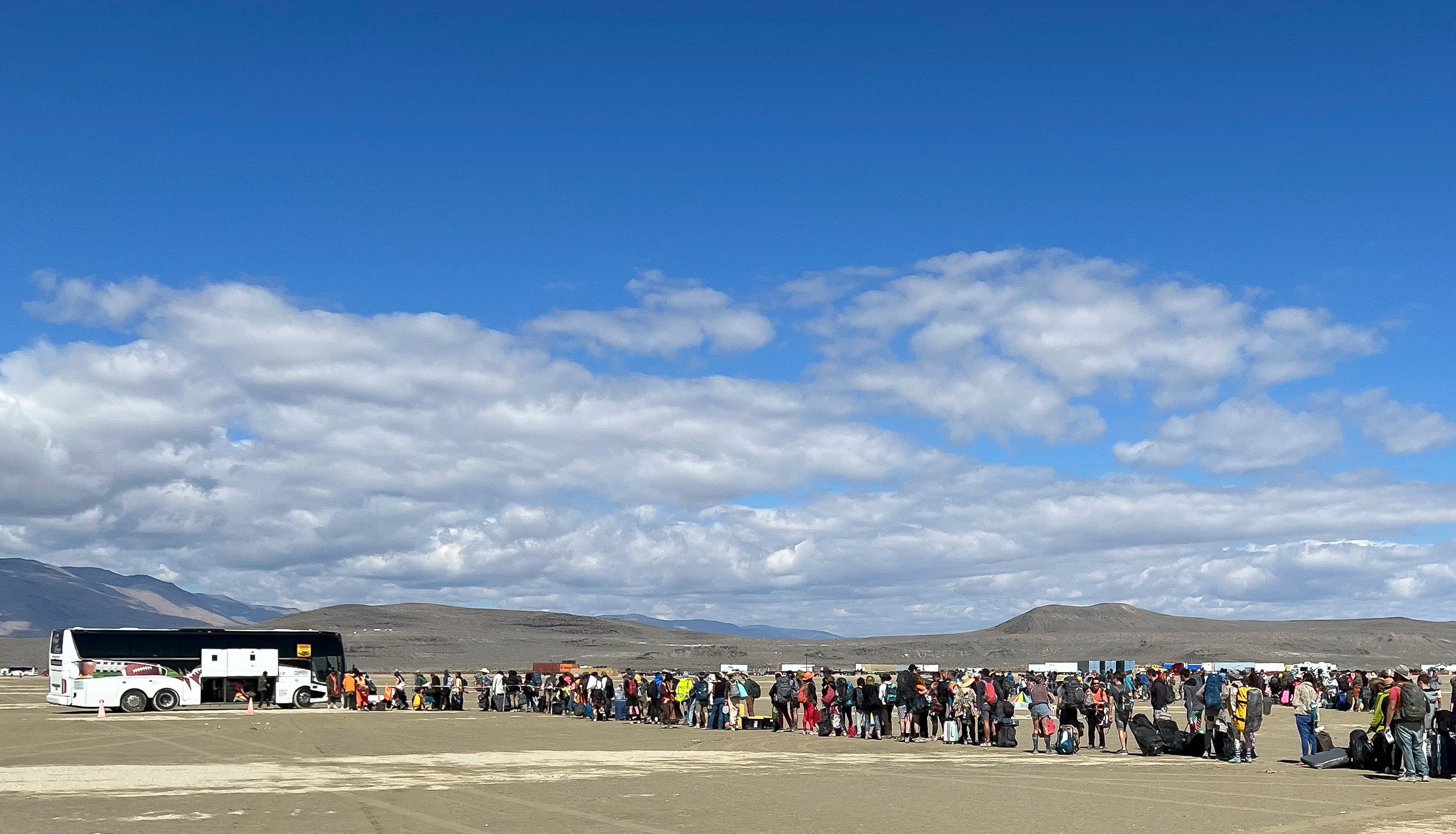 People wait in line for a bus to leave the Burning Man festival in Black Rock Desert, Nevada, USA, 04 September 2023