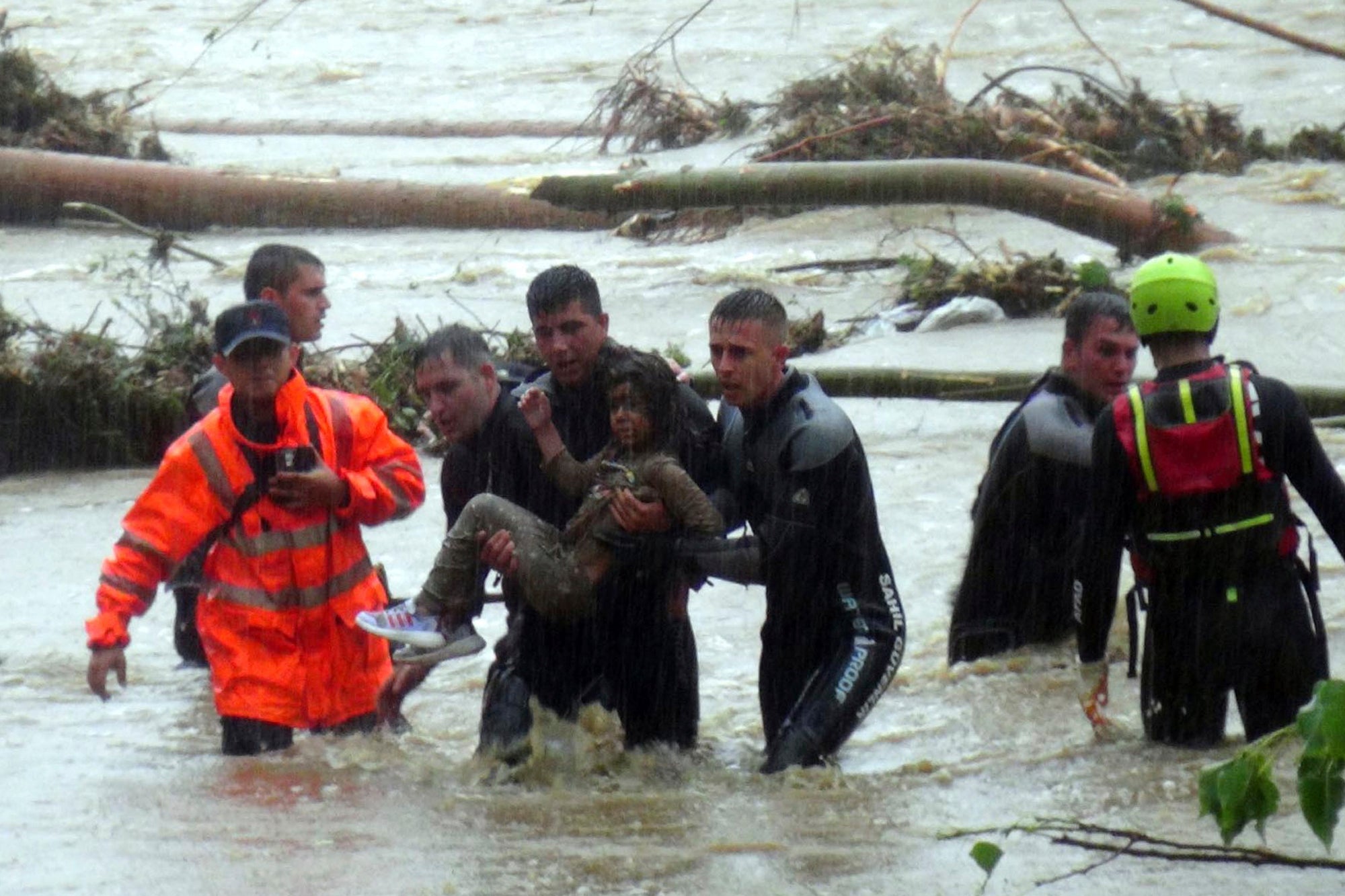 Emergency team members rescue a young girl during floods in a campsite in Kirklareli province, Turkey