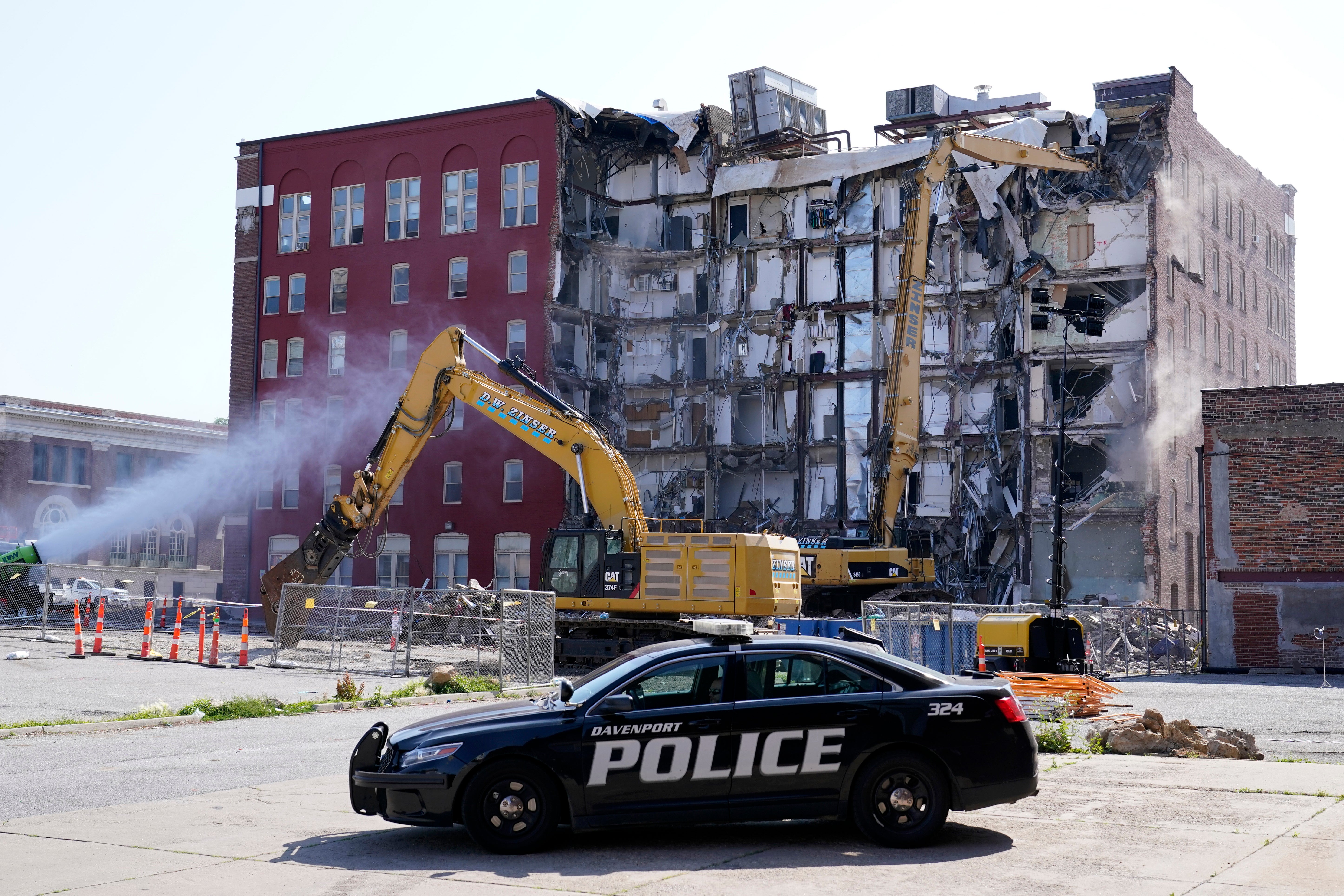 FILE - A police officer sits parked at the site of a building collapse at the start of demolition, Monday, June 12, 2023, in Davenport, Iowa.