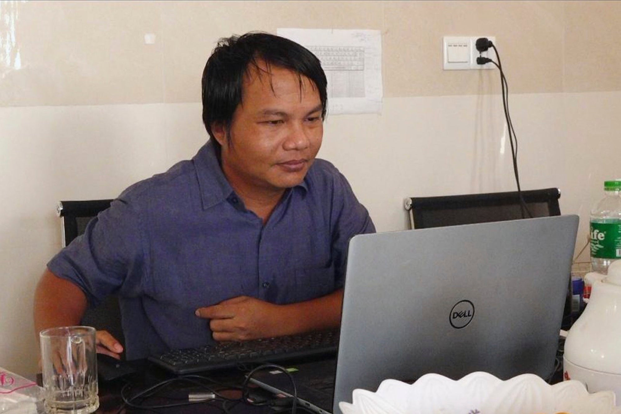 Sai Zaw Thaike, a photojournalist for the independent news website Myanmar Now, works at his desk in Yangon