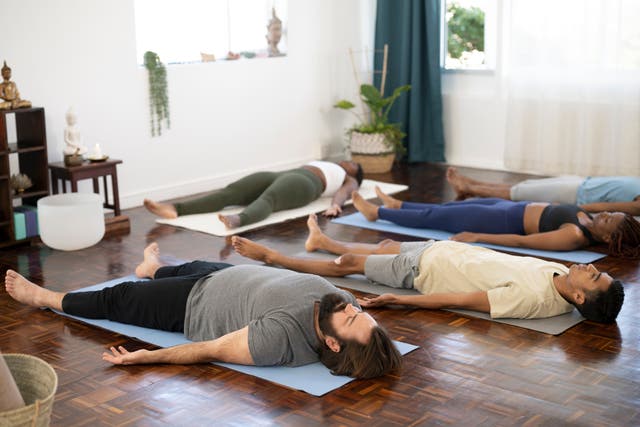 <p>(File image) People lying down in Shavasana at end of yoga class </p>