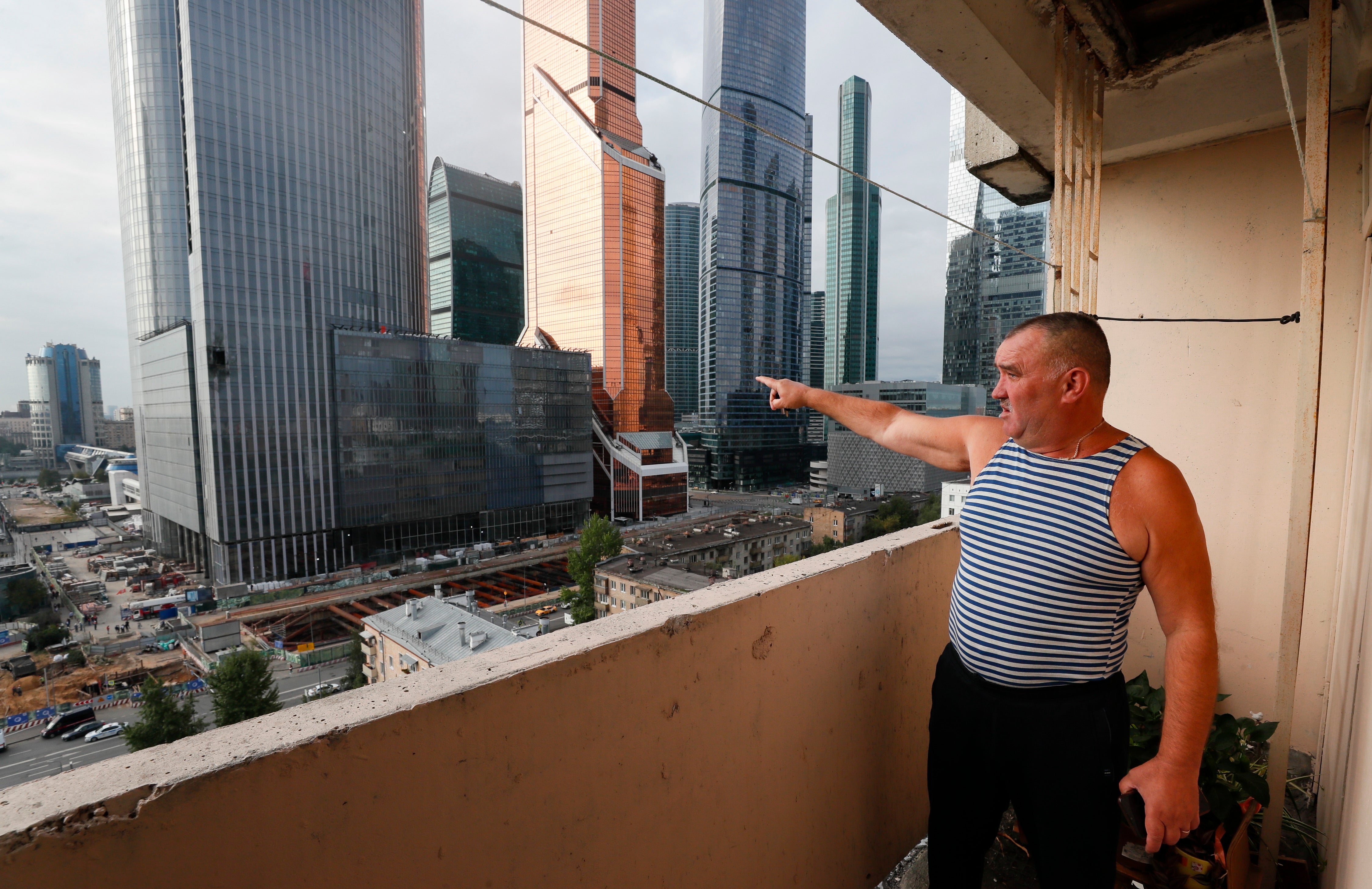 A Moscow resident points at a damaged building in the city’s business district after a drone attack on 23 August