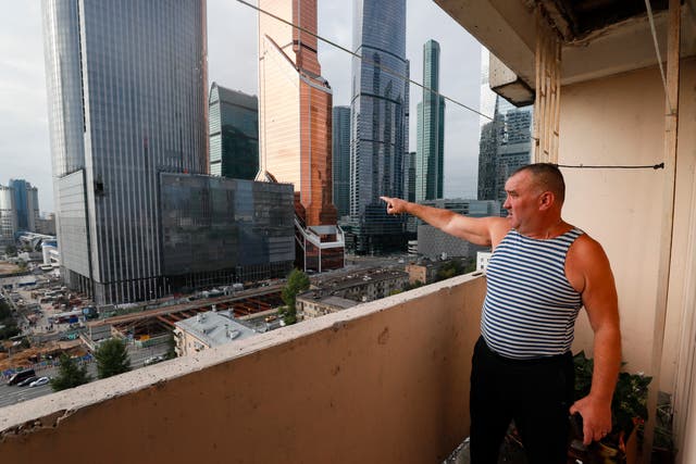 <p>A Moscow resident points at a damaged building in the city’s business district after a drone attack on 23 August </p>