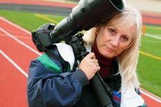 Photographer dies after high school football players crash into her during game