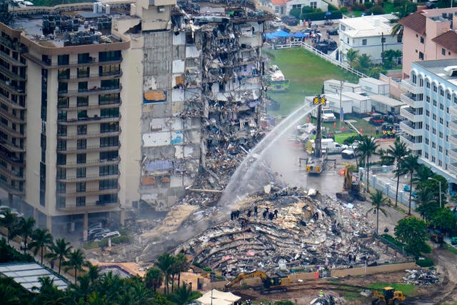 <p>Rescue personnel work at the remains of the Champlain Towers South condo building, June 25, 2021, in Surfside, Florida </p>