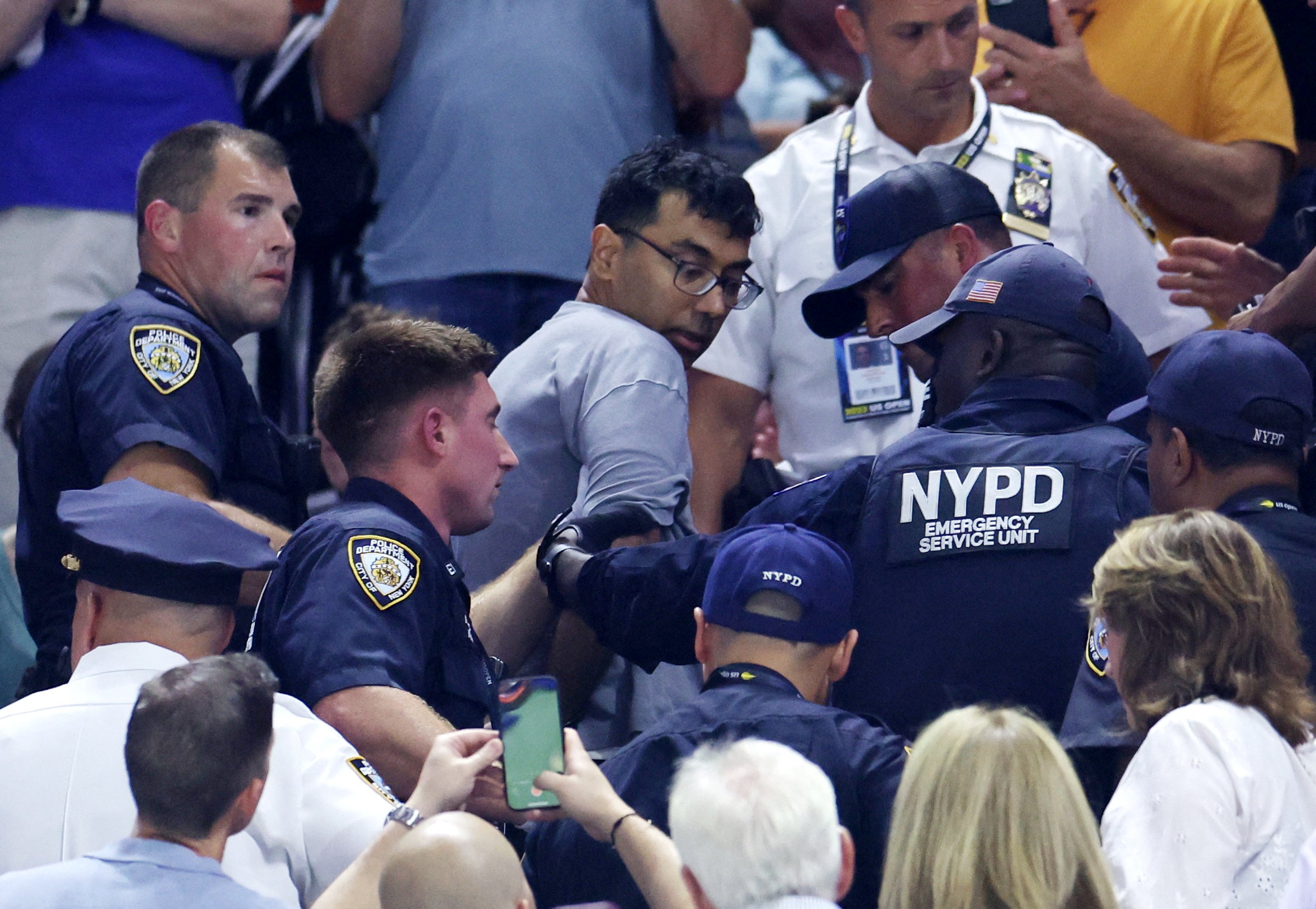 A demonstrator is removed from the Arthur Ashe Stadium by New York City Police