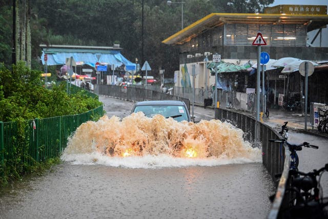 <p> A motorist drives through floodwaters on Lantau Island in Hong Kong </p>