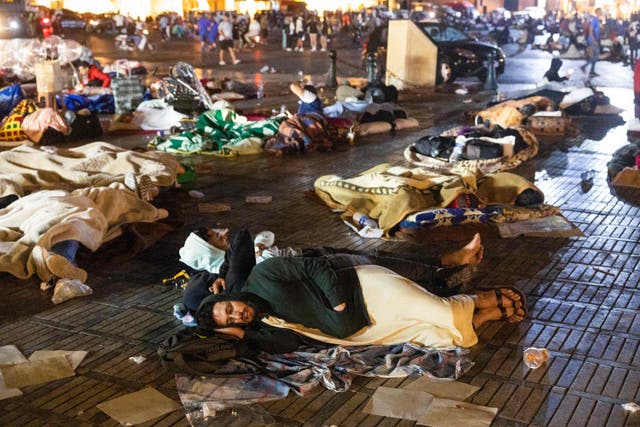 <p>Residents take shelter outside at a square following an earthquake in Marrakesh on 9 September</p>