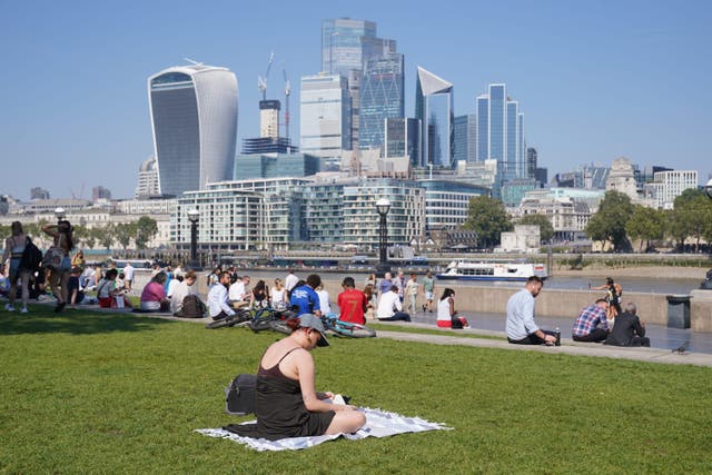 People enjoying the warm weather in Potters Field near Tower Bridge, London (Lucy North/PA)