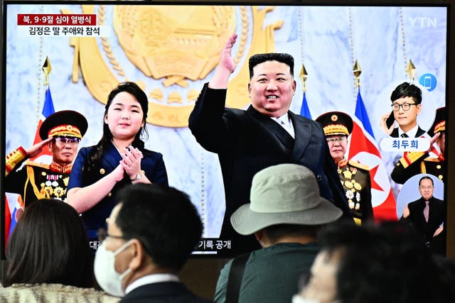 <p>People sit in front of a television showing a news broadcast with a photo of North Korea’s leader Kim Jong-un (centre) and his daughter (left) attending a parade marking the 75th anniversary of the country’s founding, at a railway station in Seoul on 9 September 2023</p>
