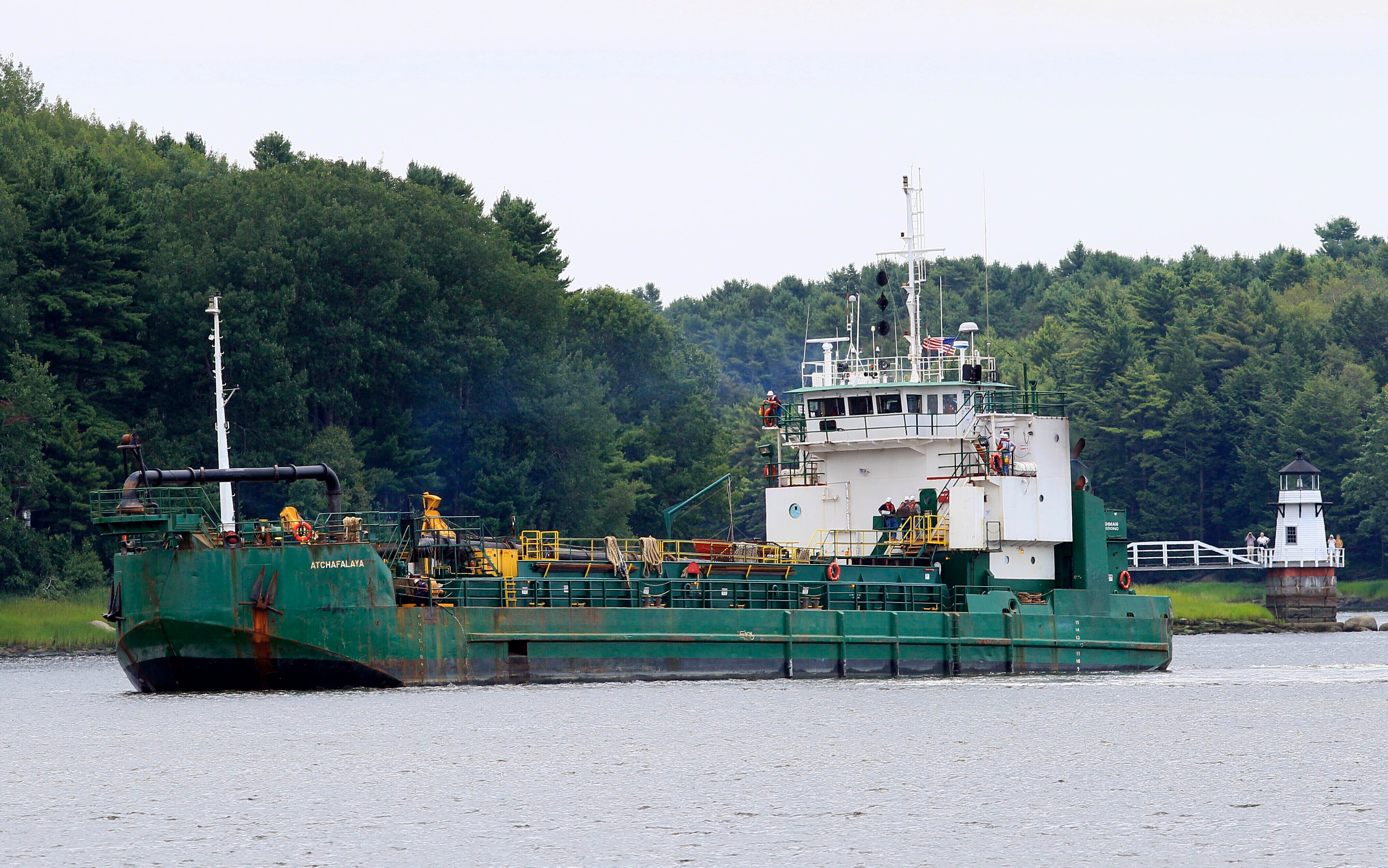 File photo: Spectators watch as a dredger works to deepen a shallow channel in the Kennebec River, upstream from the Doubling Point Lighthouse, Aug. 5, 2011, in Arrowsic, Maine