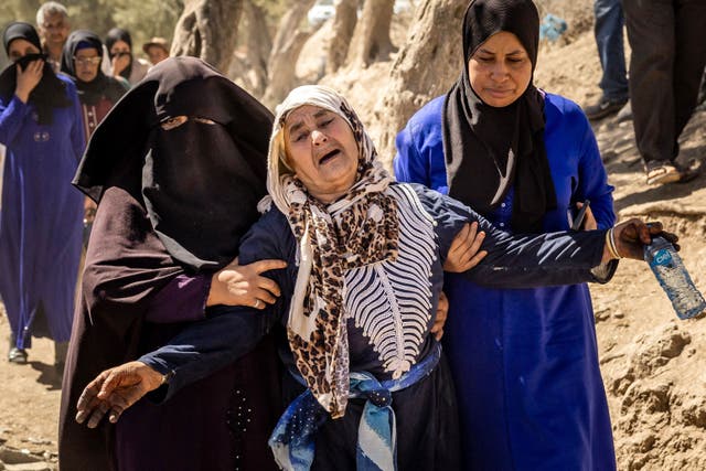 <p>A woman is helped as she reacts to the death of relatives in the mountain village of Tafeghaghte, southwest of Marrakech </p>