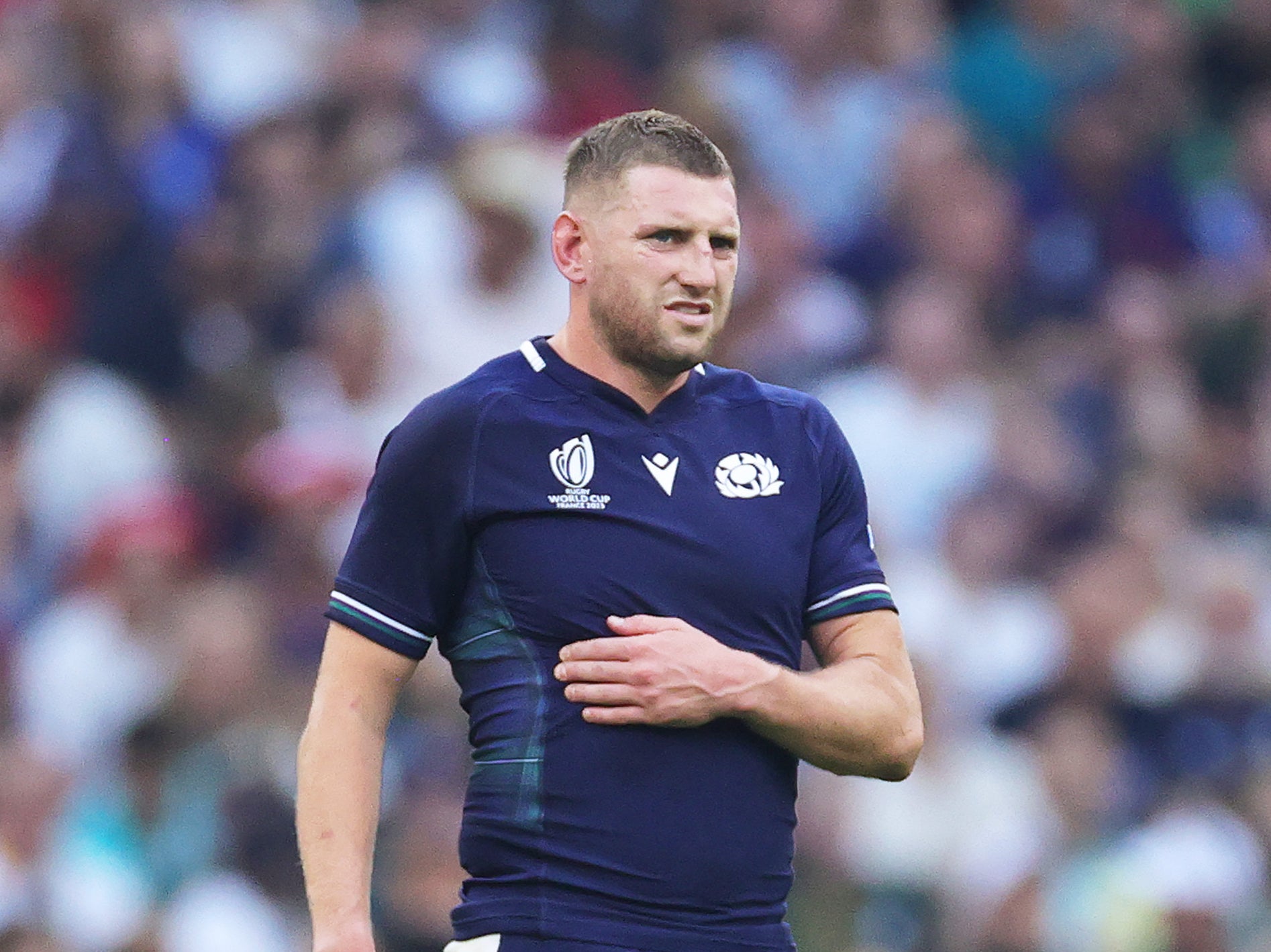 Finn Russell of Scotland clutches his ribs having appeared to have suffered an injury