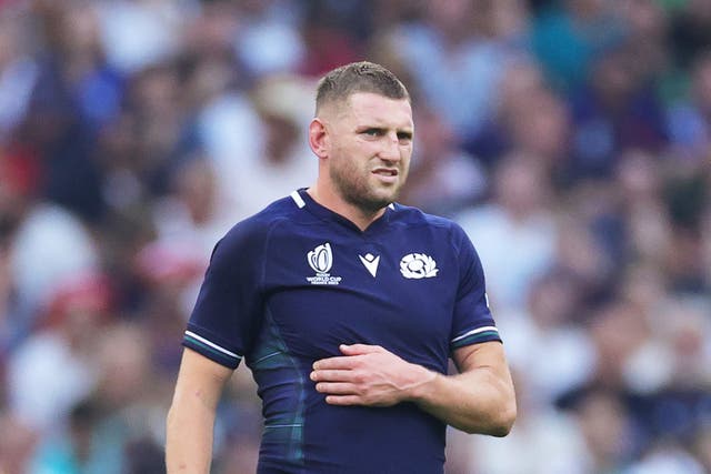 <p>Finn Russell of Scotland clutches his ribs having appeared to have suffered an injury</p>