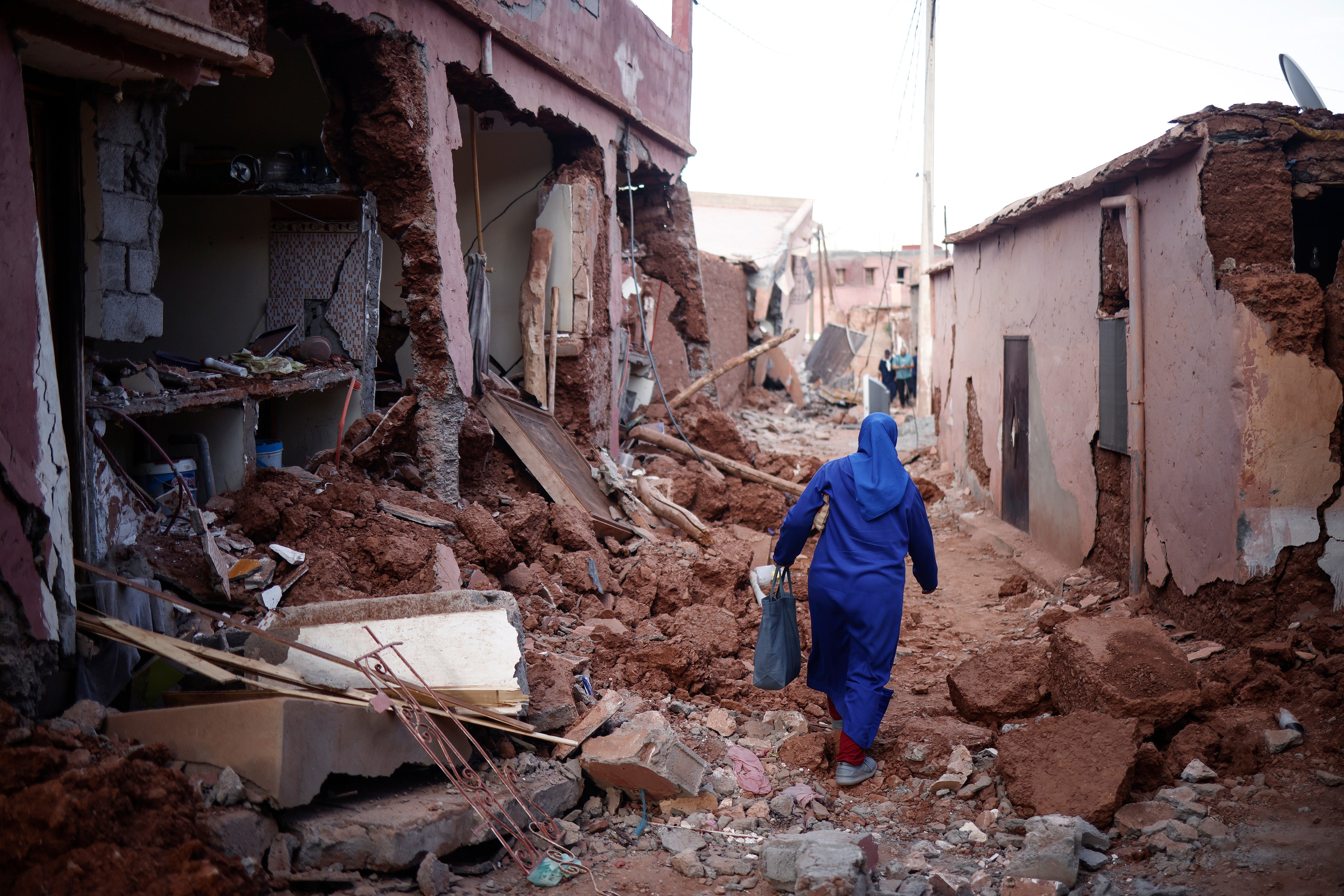 File photo: A woman passes by damaged buildings following a powerful earthquake in Ouirgane, south of Marrakesh
