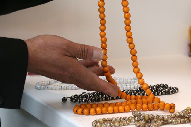 A man holds prayer beads (Andrew Milligan/PA)