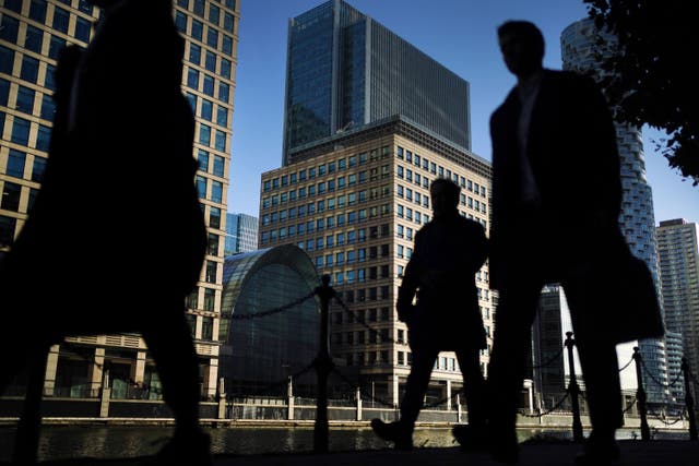 Office workers and commuters walking through Canary Wharf in London (Victoria Jones/PA)
