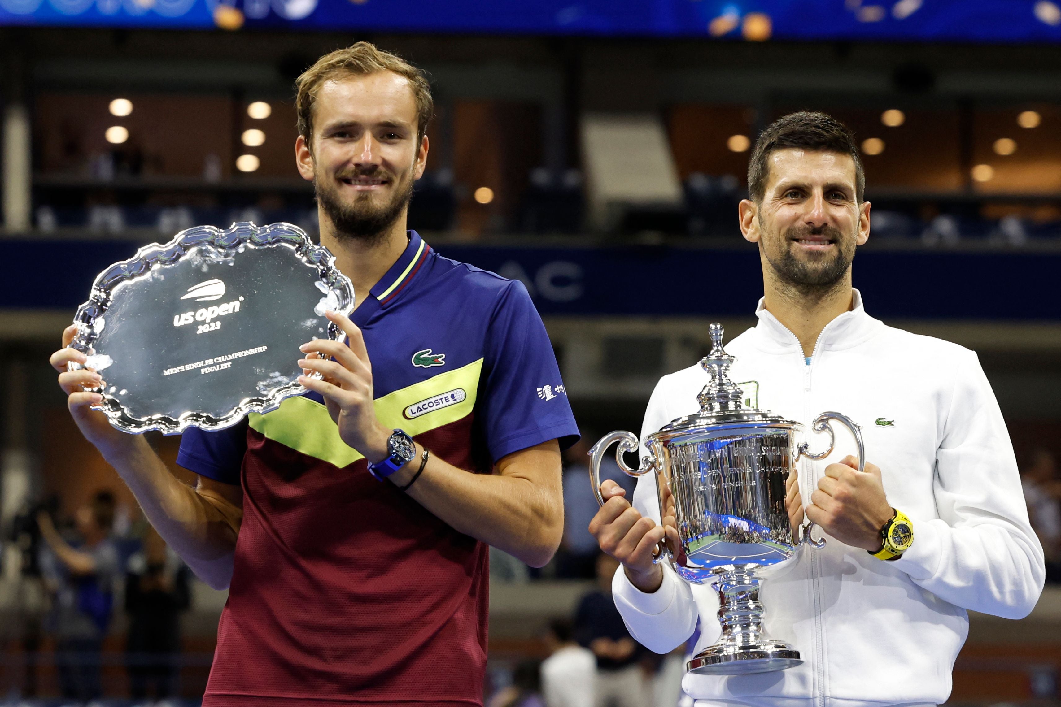 Novak Djokovic poses with the trophy after defeating Russia's Daniil Medvedev, left