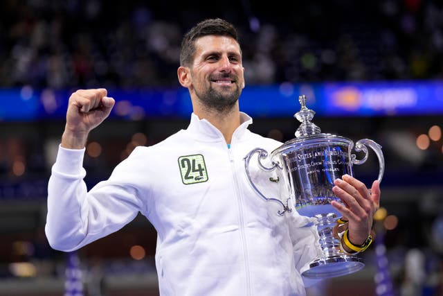 Novak Djokovic holds up the trophy (Manu Fernandez/AP)