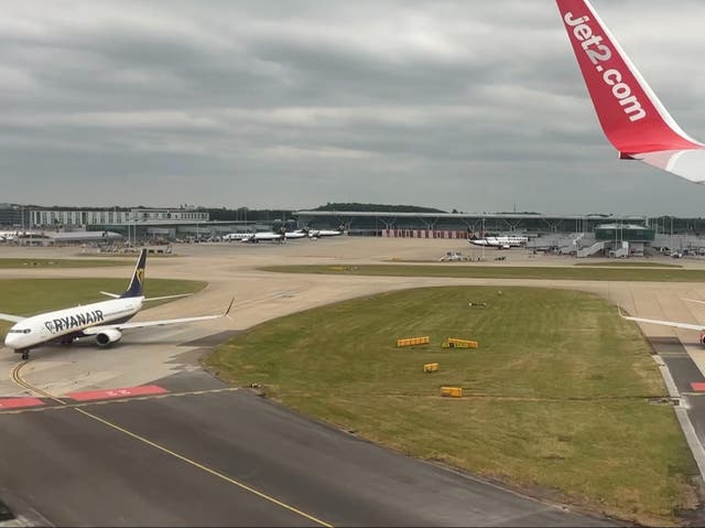 <p>Quick turnaround: Jet2 Boeing 737 landing at London Stansted while a Ryanair aircraft waits to depart</p>