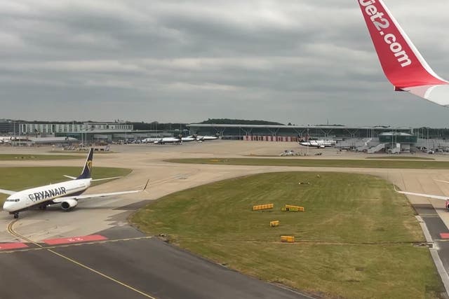 <p>Quick turnaround: Jet2 Boeing 737 landing at London Stansted while a Ryanair aircraft waits to depart</p>