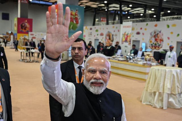 <p>India's Prime Minister Narendra Modi (C) waves to the media during his visit to the International media centre, at the G20 summit venue</p>
