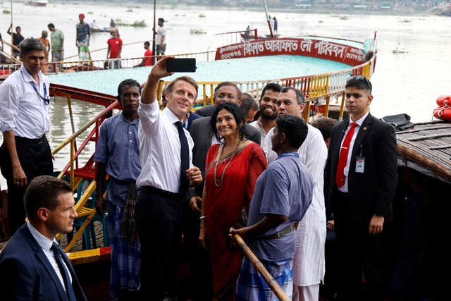 <p>France’s President Emmanuel Macron (C) takes a selfie with Bangladeshi locals and members of an NGO after a boat ride during his two-day visit in Dhaka</p>